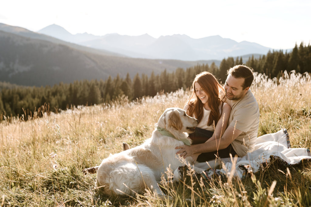 couple in the mountains with their dog during golden hour